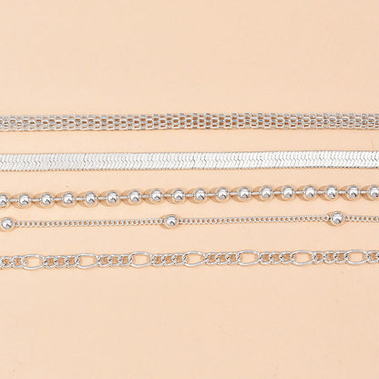 5-teiliges Set aus silbernen Schlangenketten- und Perlen-Fußkettchen für Damen.