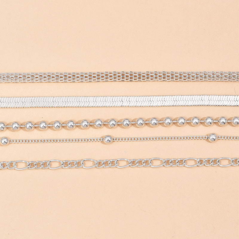5-teiliges Set aus silbernen Schlangenketten- und Perlen-Fußkettchen für Damen.