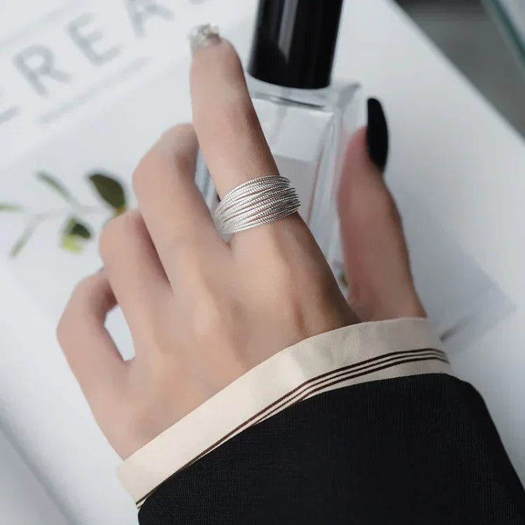 Silberner Damenring, mehrschichtig, elegantes Design, getragen an Hand, Nahaufnahme.