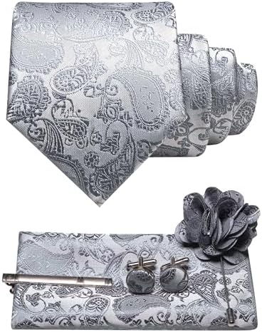 Silvergrått paisleyslips med ljusare mönster, bröstnäsduk, manschettknappar, slipsklämma och blomformad kavajnål. 31