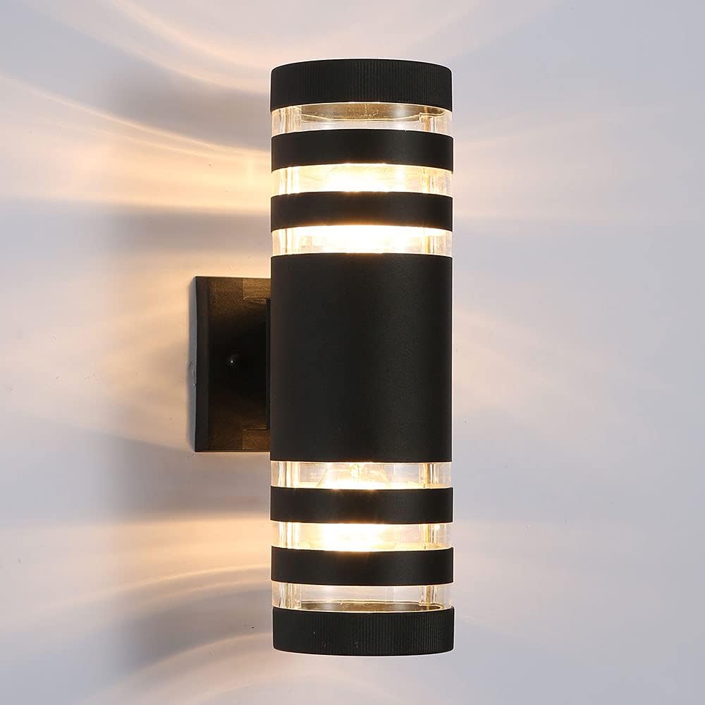Frontbild av svart cylindrisk vägglampa med tre genomskinliga ljusband upptill och nedtill mot ljus vägg 19