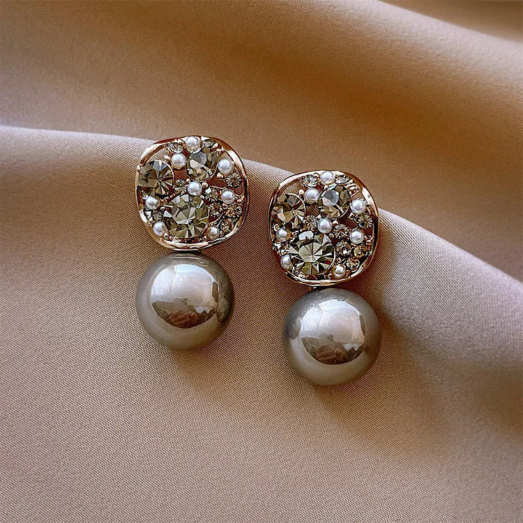 Elegante Ohrringe mit Perlen und Strasssteinen auf beigem Stoff, Schmuck, Accessoires.
