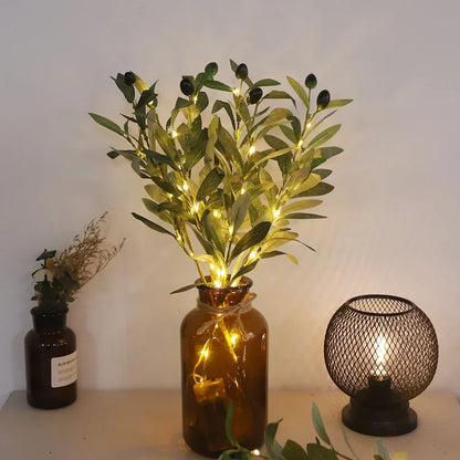 Braune Glasvase mit Olivenzweigen und LED-Lichterkette, dekorative Beleuchtung.