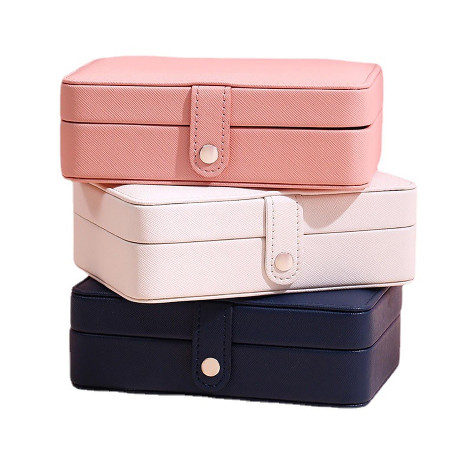 Drei stapelbare Schmuckkästchen in Rosa, Weiß und Blau aus Leder mit Druckknopfverschluss.