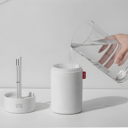 Weißer Luftbefeuchter mit Wasserbehälter, minimalistisches Design, Tischgerät, moderne Raumluftpflege.
