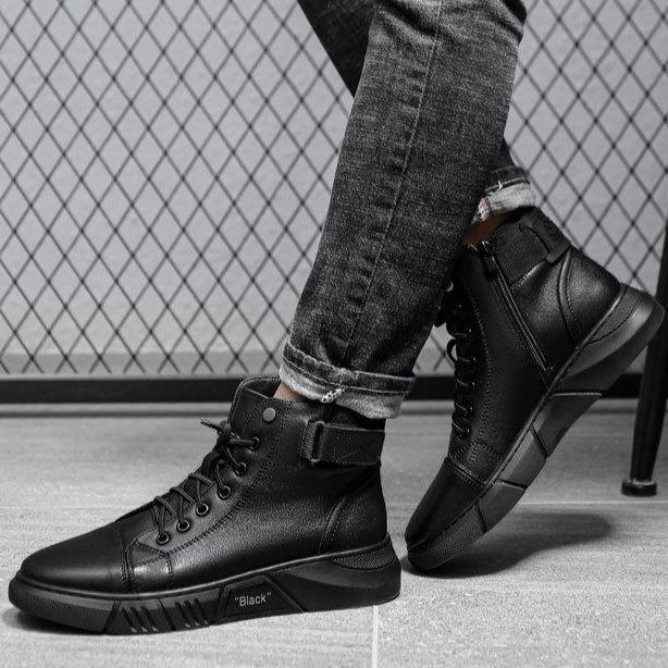 Schwarze Herren-Sneaker aus Leder, hohe Knöchel, modern, lässig, vor Gitterhintergrund.
