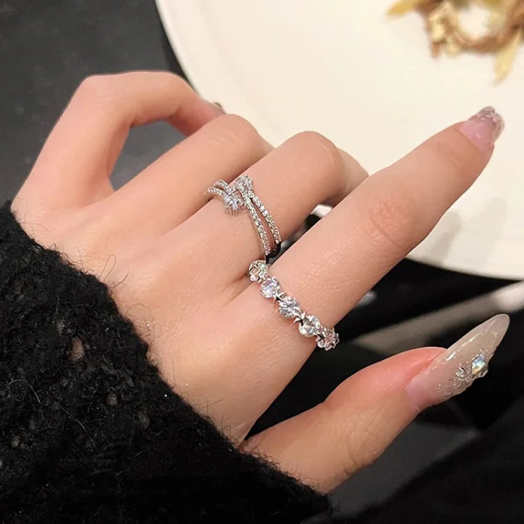 Damenhand mit silbernen Diamantringen, funkelnd, elegantes Schmuckdesign, Nahaufnahme.