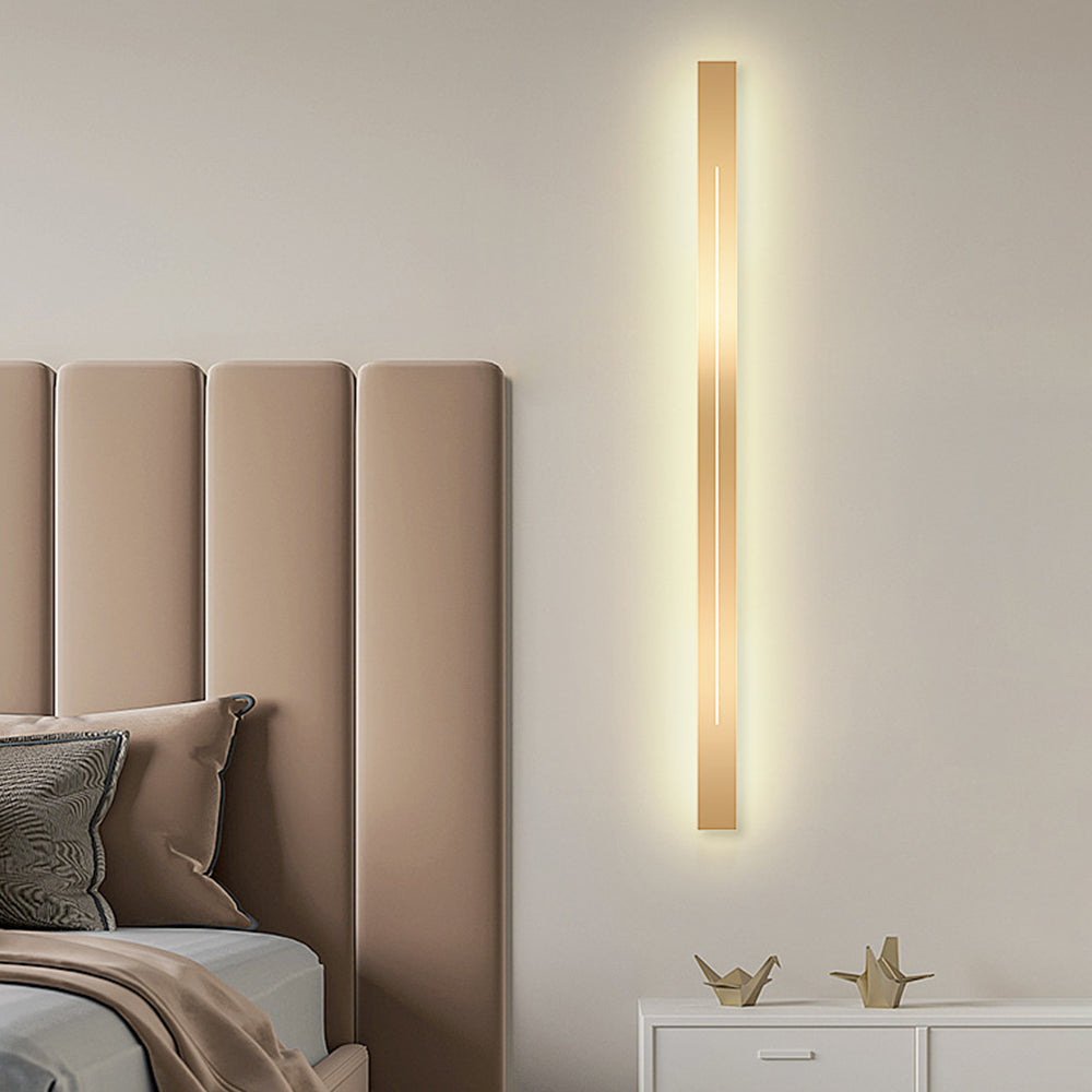 Moderne goldene Wandleuchte im Schlafzimmer, vertikal, LED, minimalistisches Design, beige Wand.