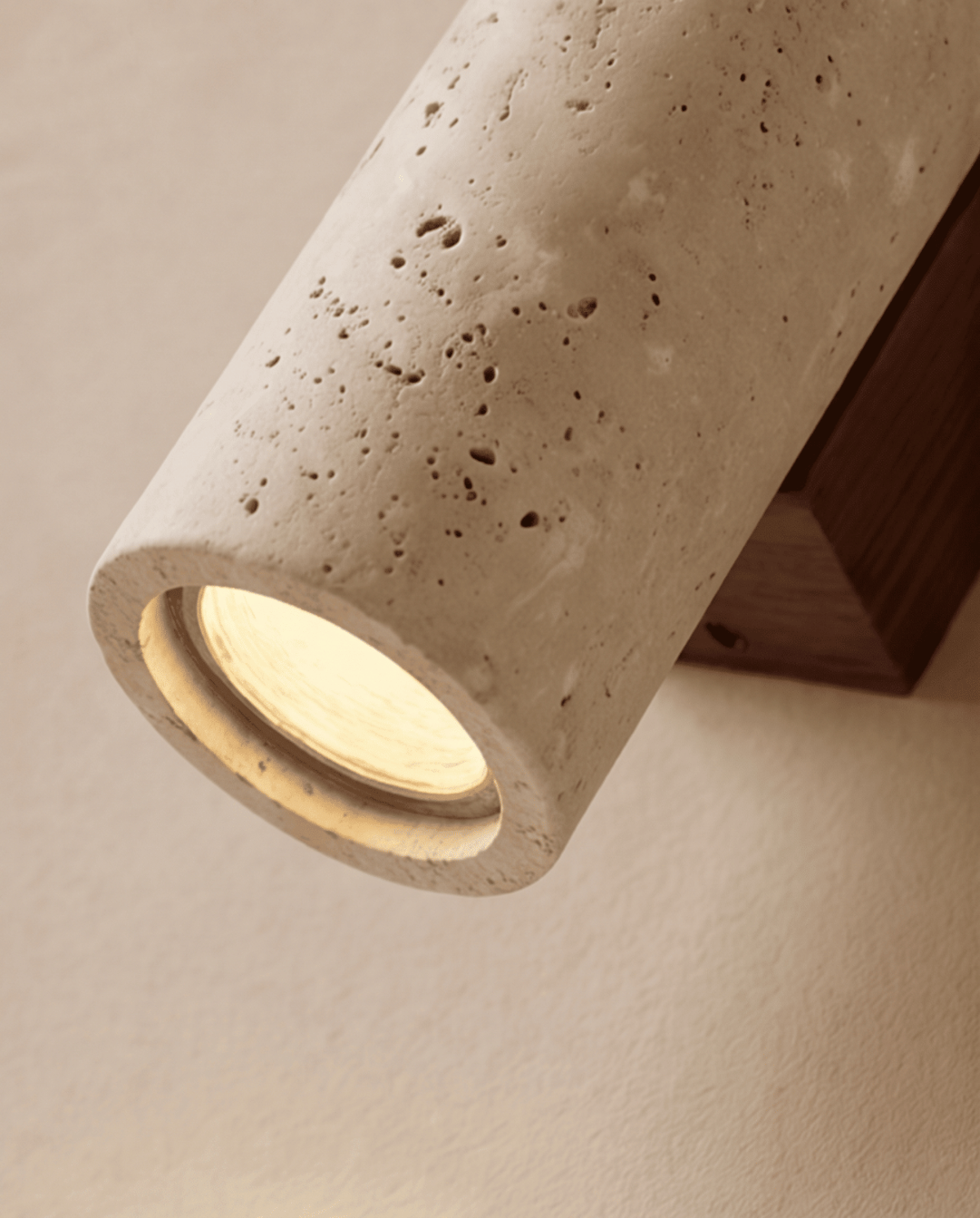 Närbild på lampans nedre öppning med glödande ljus, porig sten och träfästet i bakgrunden 5