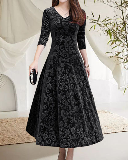Frau in schwarzem Samtkleid mit floralen Mustern, elegantes Abendkleid, langärmelig, V-Ausschnitt.