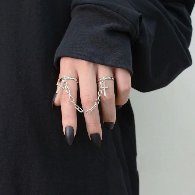 Silberne Kettenringe an Hand, schwarzes Oberteil, gotischer Schmuck, modisches Accessoire.