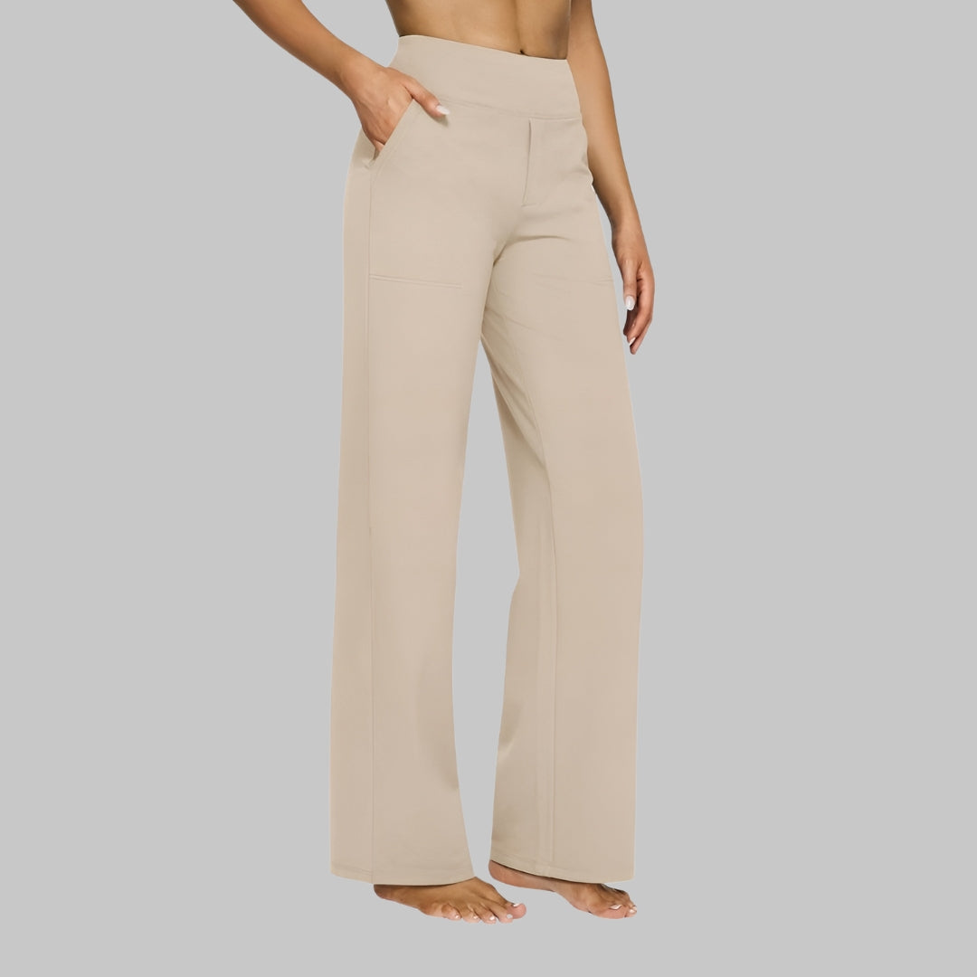 Ljusbeige högmidjade byxor med rak passform, snett framifrån på modell med handen i fickan. 7