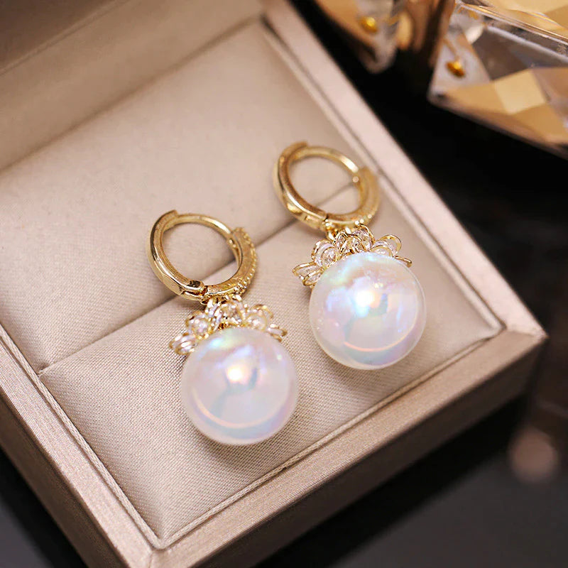Goldene Ohrringe mit großen Perlen, elegantes Schmuckdesign, luxuriöses Accessoire.