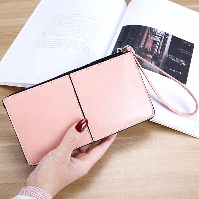Damenhandtasche aus rosa Leder mit Reißverschluss, elegant, modisch, auf Holztisch.