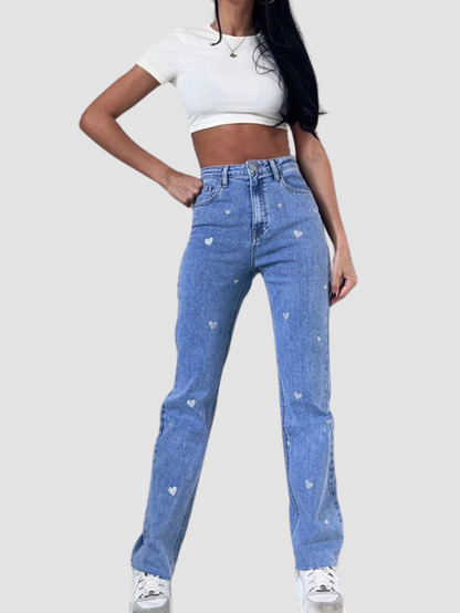 Frau in blauer Jeans mit Herzmuster, weißes Crop-Top, lässiger Stil, Mode, Damenbekleidung.