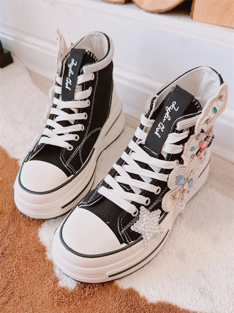Schwarze High-Top-Sneaker mit weißen Schnürsenkeln und bunten Verzierungen, Damenmode.