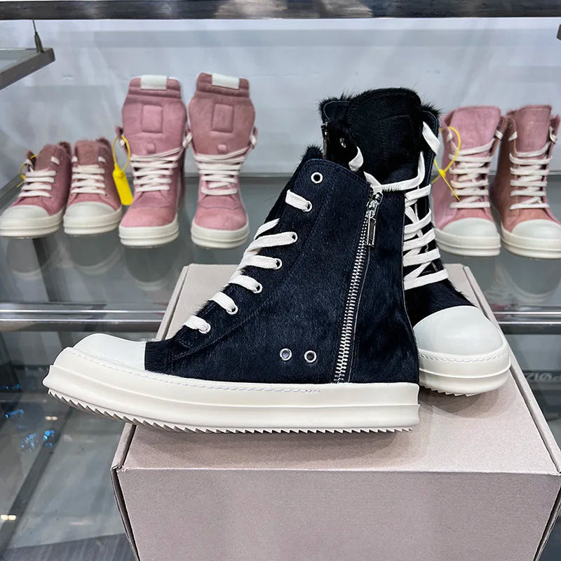 Schwarze High-Top-Sneaker mit Reißverschluss, Leder, Unisex, vor rosa Schuhen im Hintergrund.
