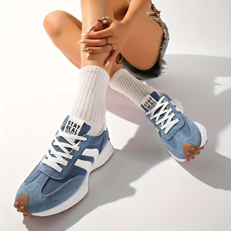 Blå skor med vita ränder, bäras av sittande modell med vita ribbade strumpor och shorts 9