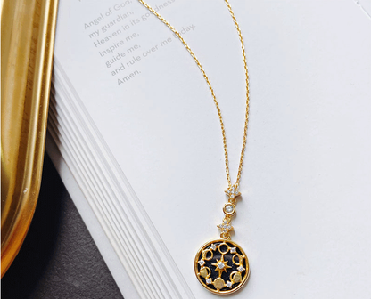 Goldene Halskette mit rundem Anhänger auf Buch, elegantes Schmuckdesign, Damenaccessoire.