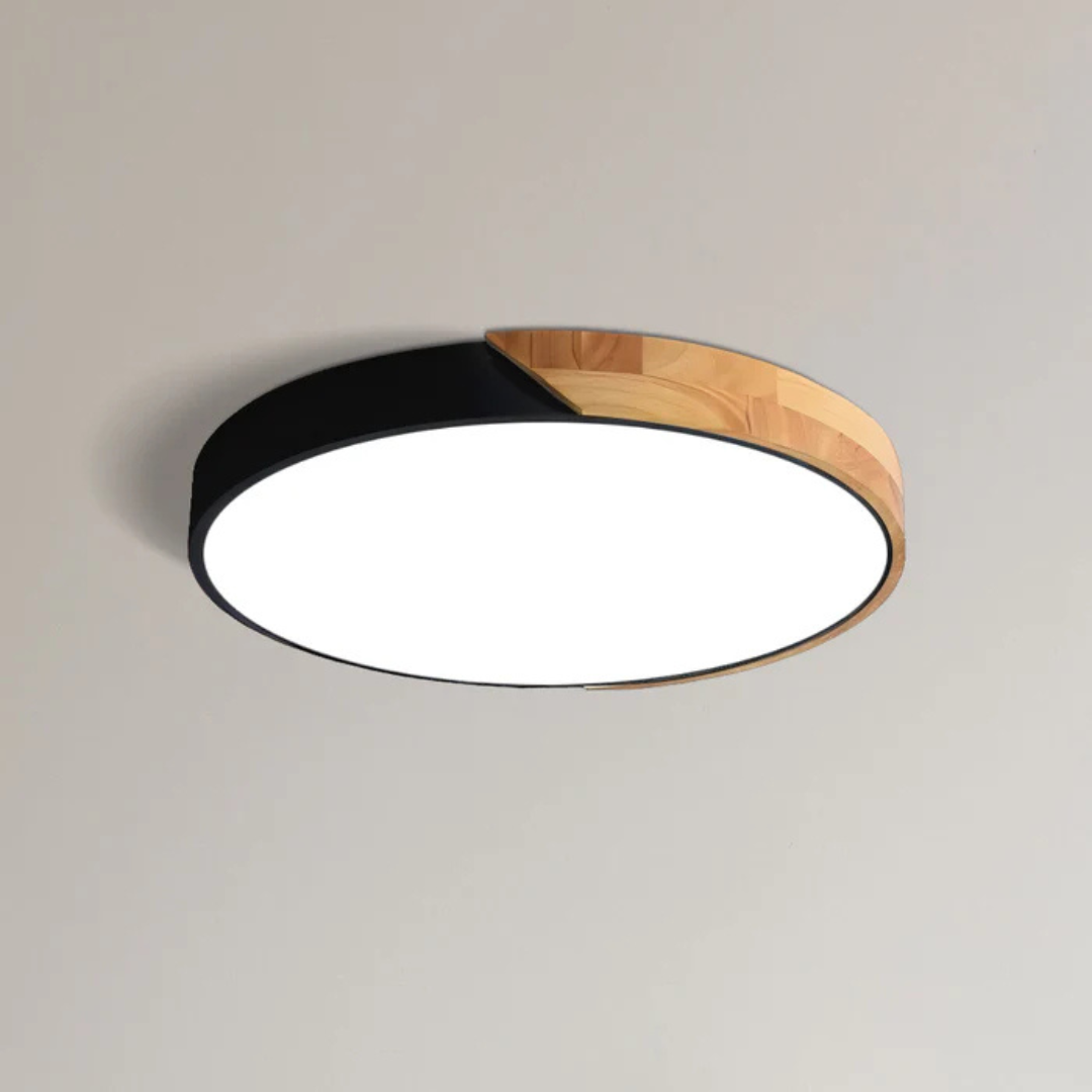 Svart takplafond med träparti sedd snett underifrån, tänd med vit diffusor 9