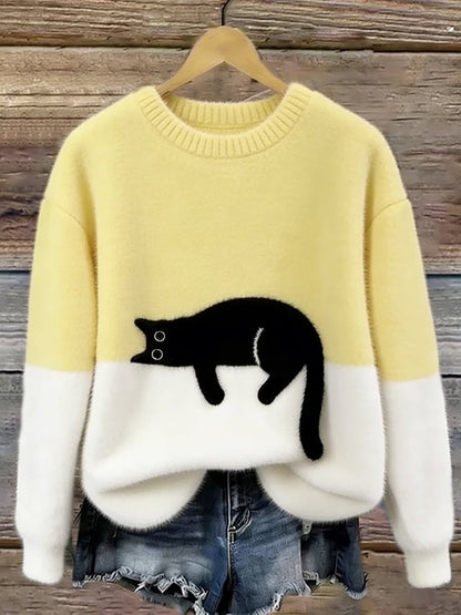 Ljusgul och vit luddig tröja med liggande svart katt hänger på galge 8