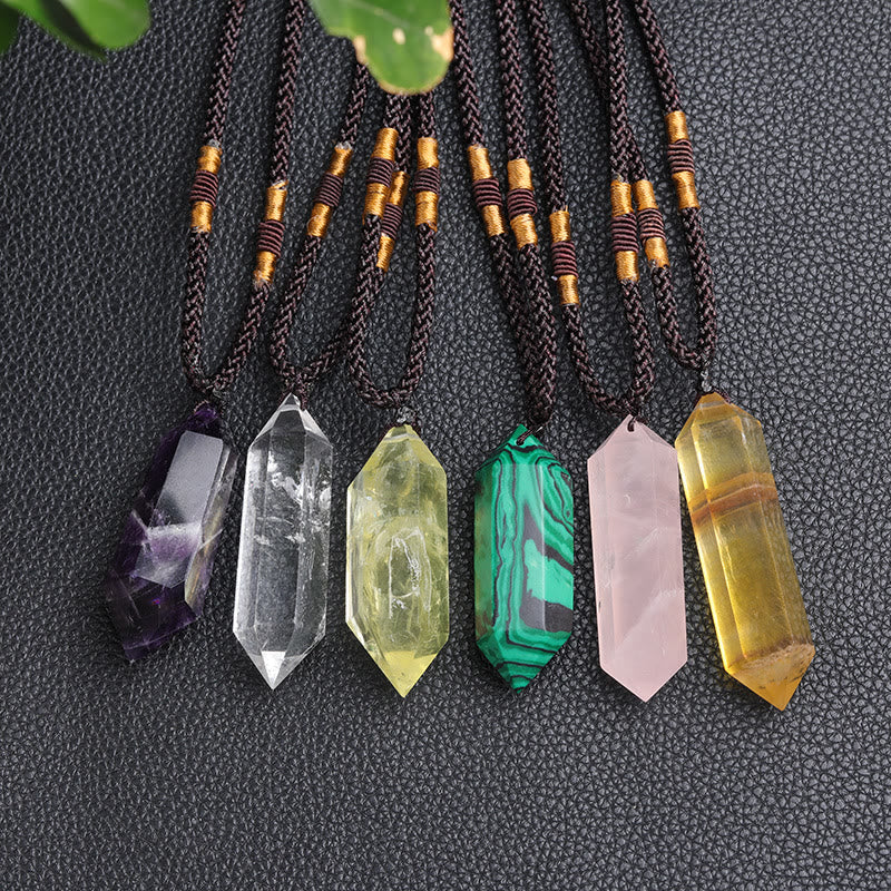 Verschiedene Kristallanhänger auf schwarzem Hintergrund, Amethyst, Quarz, Malachit, Rosenquarz.