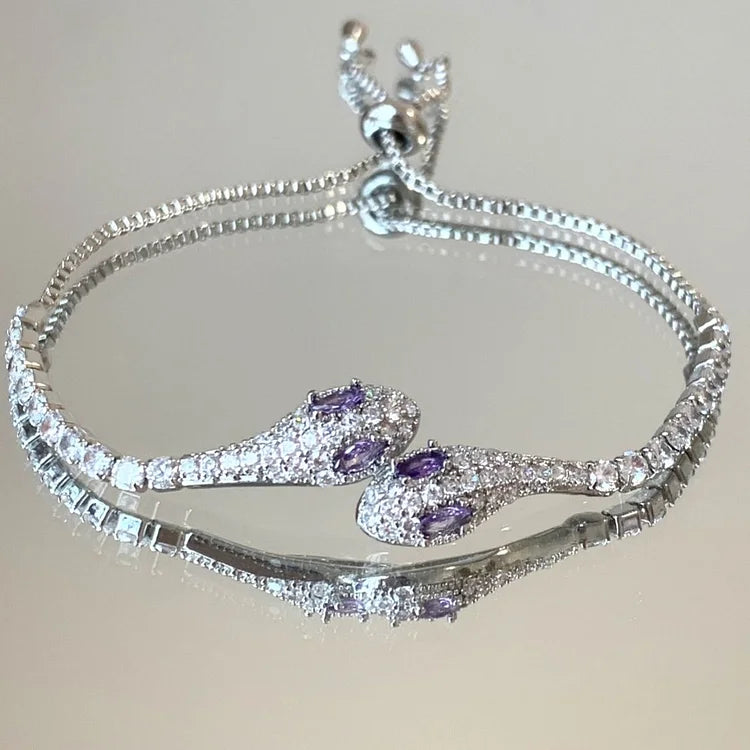 Silbernes Schlangenarmband mit lila Edelsteinen, verstellbar, elegantes Schmuckdesign.