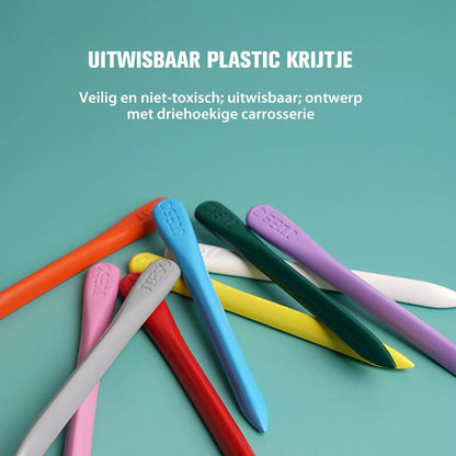 Bunte, dreieckige, ungiftige, ausradierbare Plastikkreide auf grünem Hintergrund.