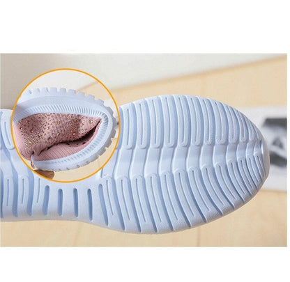 Weiße Sportschuhsohle mit rutschfestem Profil und gepolstertem, rosa Innenfutter.