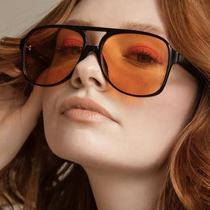 Frau mit großen, orangefarbenen Sonnenbrillen, modisches Accessoire, Nahaufnahme.