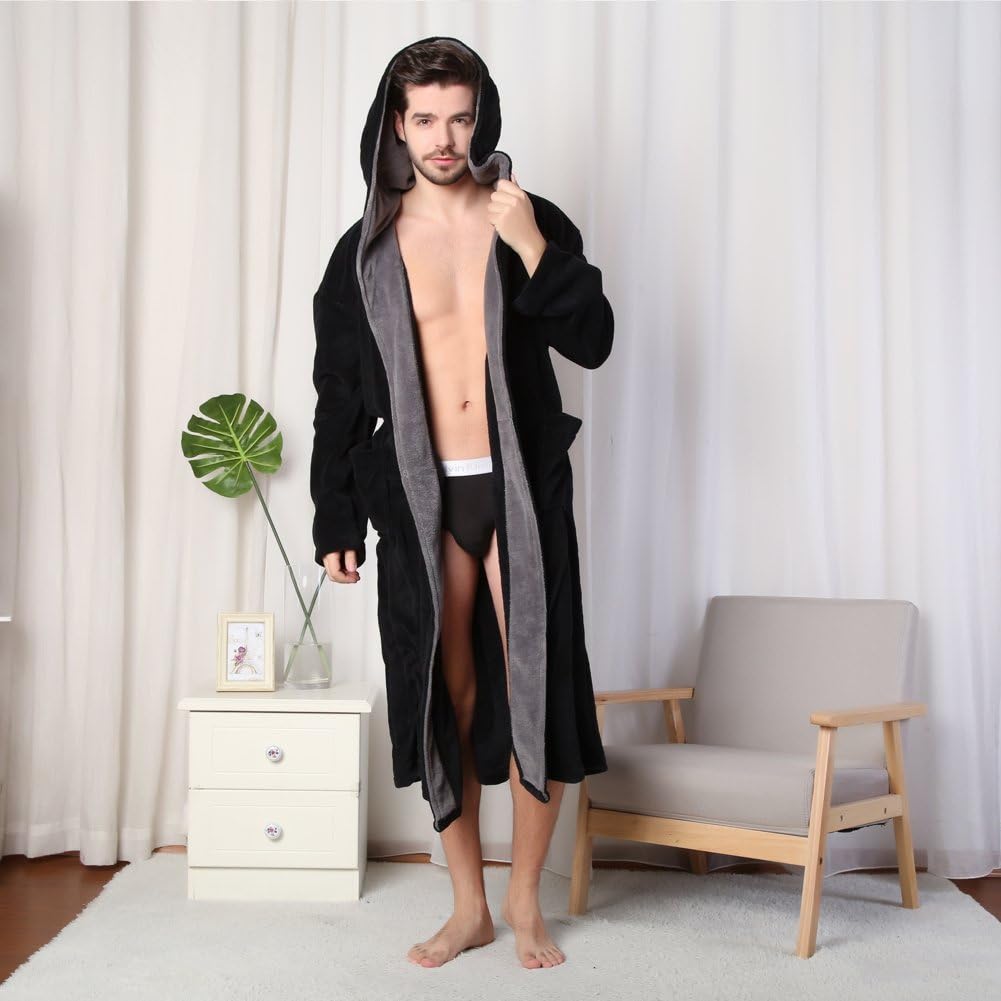 Mann im schwarzen Bademantel mit Kapuze, stehend im Wohnzimmer, moderne Einrichtung.