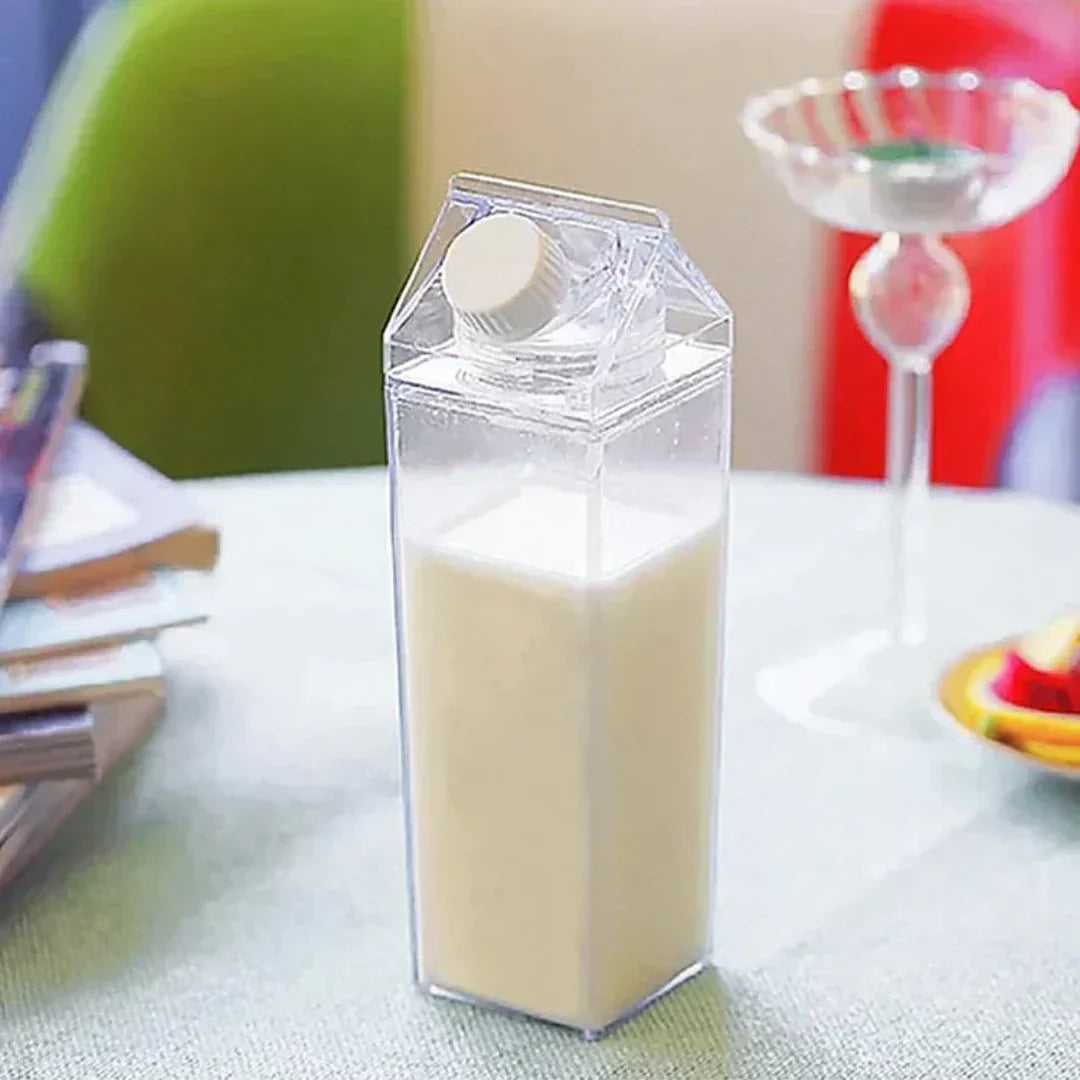 Transparente Milchflasche aus Kunststoff, quadratisch, mit Schraubverschluss, auf Tisch.