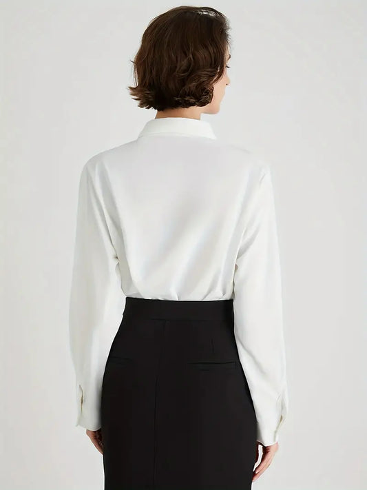 Frau in weißer Bluse und schwarzem Rock, Rückansicht, elegante Business-Kleidung.
