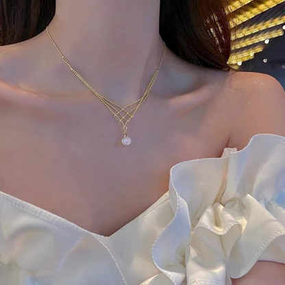 Frau mit elegantem goldenen Halskette und Perlenanhänger, weißes Kleid, Abendmode.
