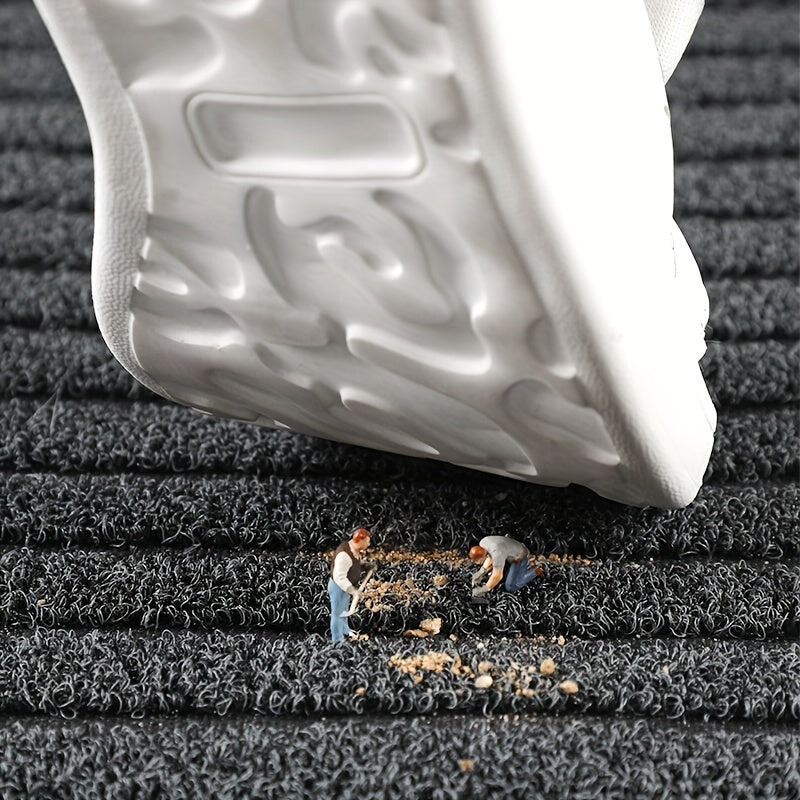 Närbild av mattan där en vit sko trycks mot ytan och miniatyrfigurer fejar bort smuts. 4