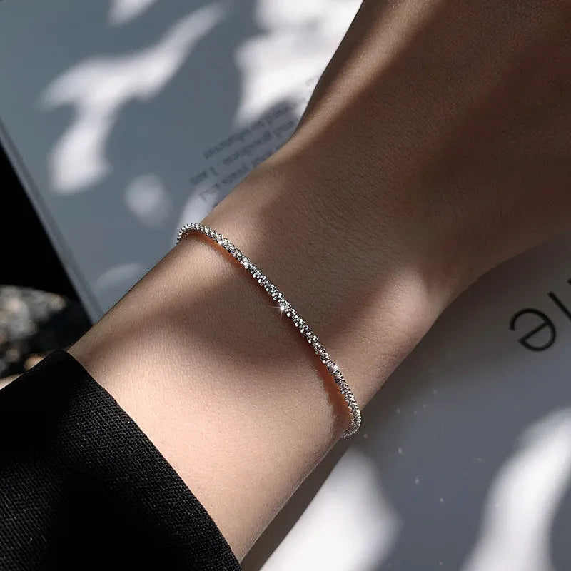 Silbernes Armband am Handgelenk, filigranes Design, eleganter Schmuck, Damenaccessoire.