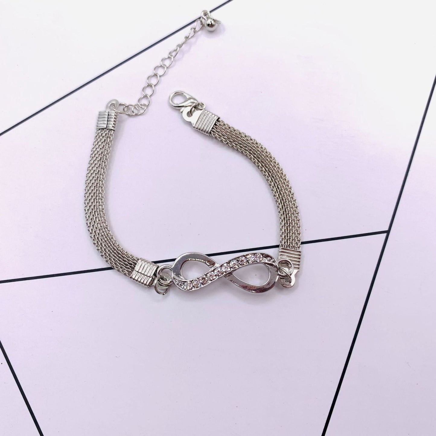 Silberarmband mit Unendlichkeitssymbol, Strasssteinen, verstellbar, elegantes Schmuckdesign.