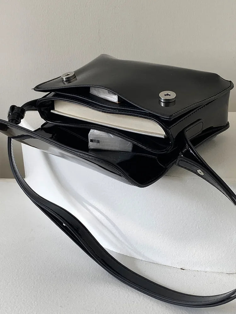 Schwarze Ledertasche mit Magnetverschluss, verstellbarem Riemen, ideal für Bücher und Alltagsgebrauch.