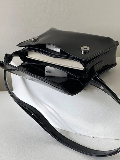 Schwarze Ledertasche mit Magnetverschluss, verstellbarem Riemen, ideal für Bücher und Alltagsgebrauch.