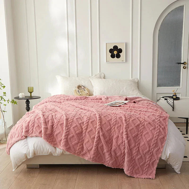 Rosa Strickdecke auf weißem Bett, gemütliches Schlafzimmer, moderne Inneneinrichtung.