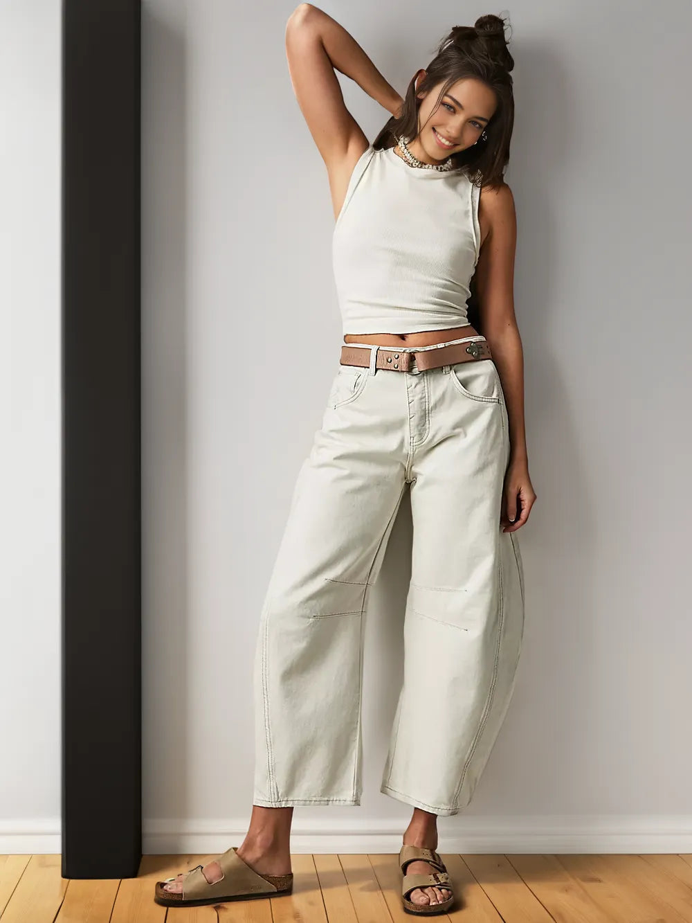 Frau in weißem Tanktop und beigen Jeans, lässiger Look, Mode, Sommeroutfit, Holzsandalen.