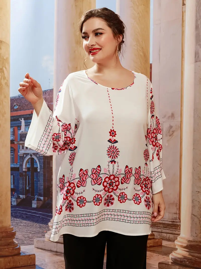 Frau in weißer Bluse mit roten Blumenmustern, lächelnd, vor antiker Architektur.
