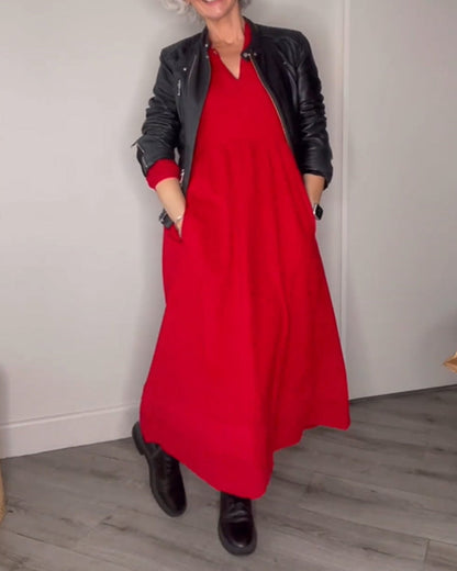 Frau in rotem Maxikleid und schwarzer Lederjacke, schwarze Stiefel, modisch, elegant.