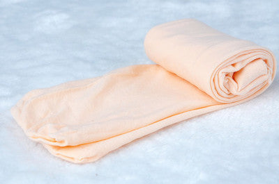Beige Baumwollstrumpfhose, weich, aufgerollt, auf weißem Hintergrund, Damenmode Accessoire.