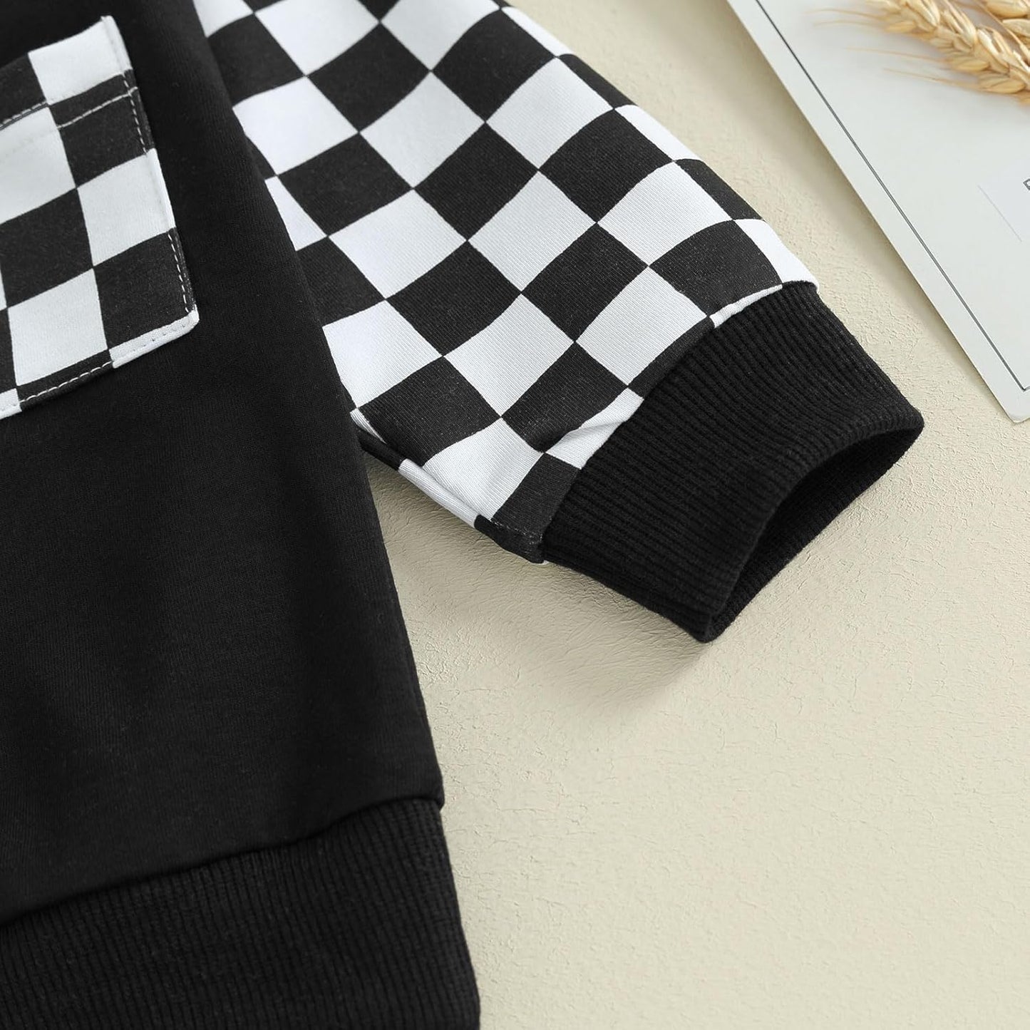 Schwarz-weiß kariertes Langarmshirt aus Baumwolle mit Tasche, Kinderkleidung, modisch.