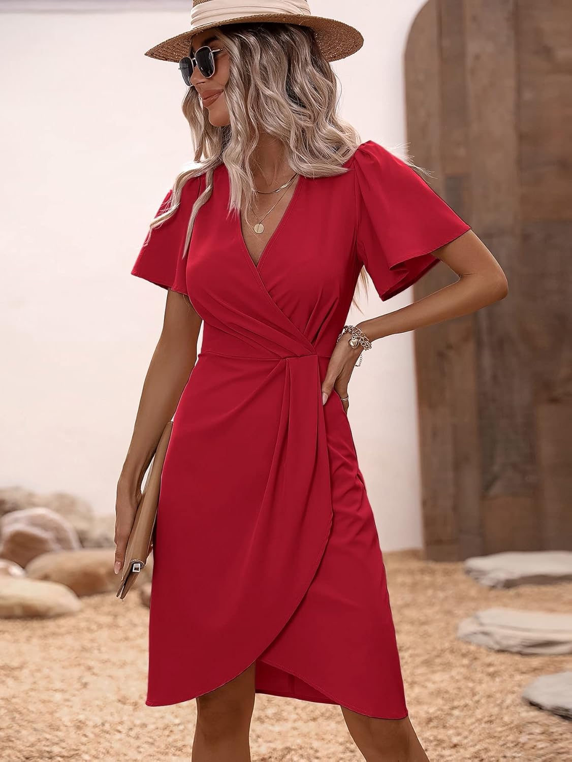 Frau in rotem Wickelkleid, Sonnenhut und Sonnenbrille, Sommermode, eleganter Look.