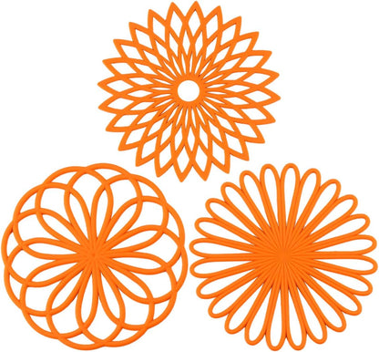 Drei orange Silikon-Untersetzer, hitzebeständig, rutschfest, dekoratives Küchendesign.