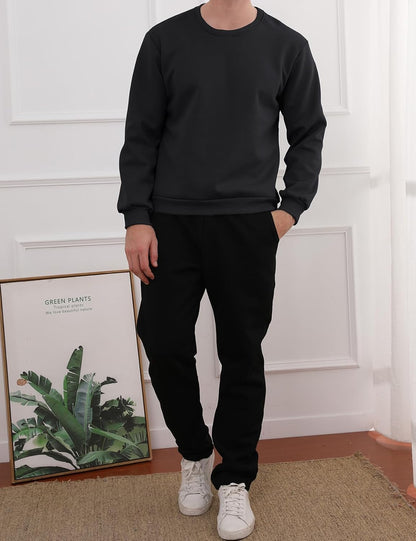 Mann in schwarzem Sweatshirt und Jogginghose, weiße Sneaker, modernes Wohnzimmer.