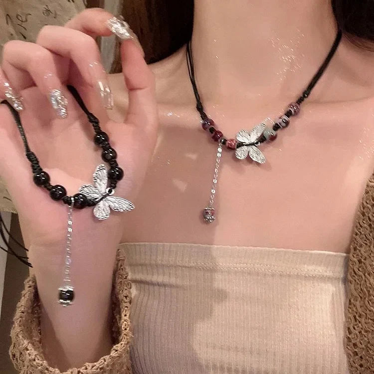 Frau mit Schmetterlingshalskette, schwarzes Lederband, silberne Anhänger, modischer Schmuck.