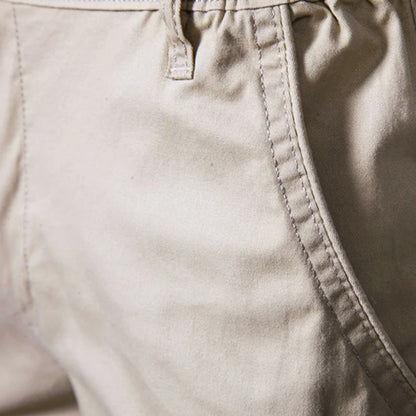 Närbild på en beige shortsficka med kantsöm och ett skärmlinningsöga vid midjan. 3